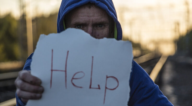 Man holding HELP sign